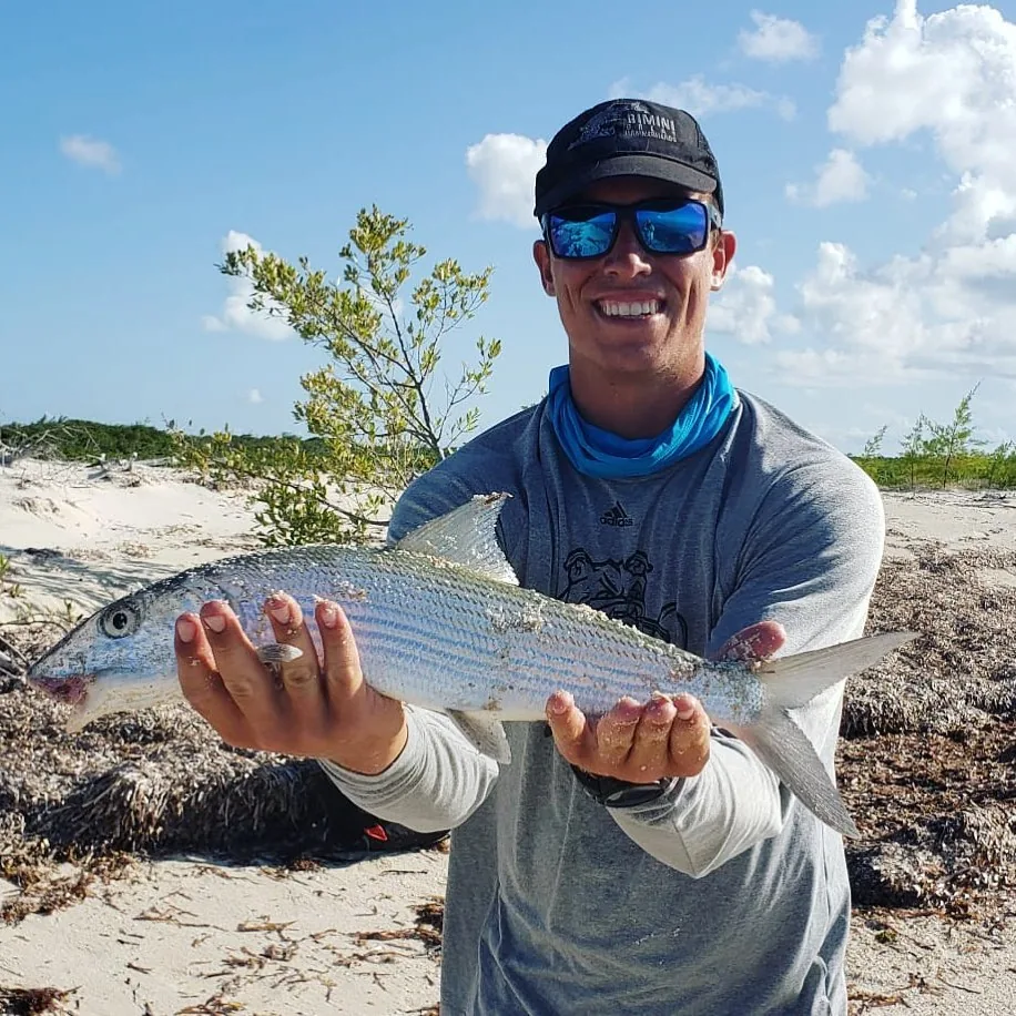 A Bimini Blue Adventures guide holding a bonefish caught on the flats
