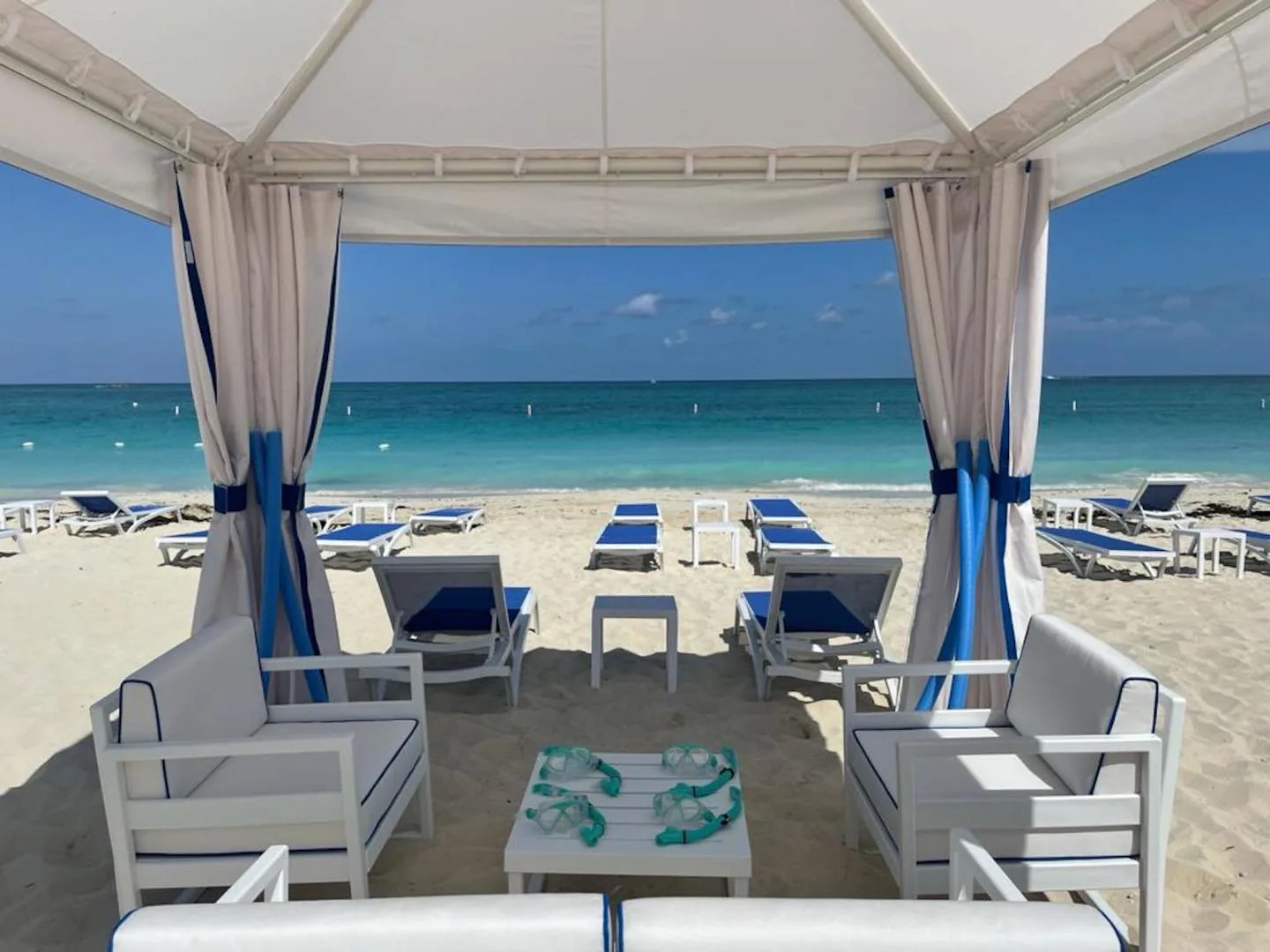 Beach cabanas and loungers set up on a white sand Bimini beach