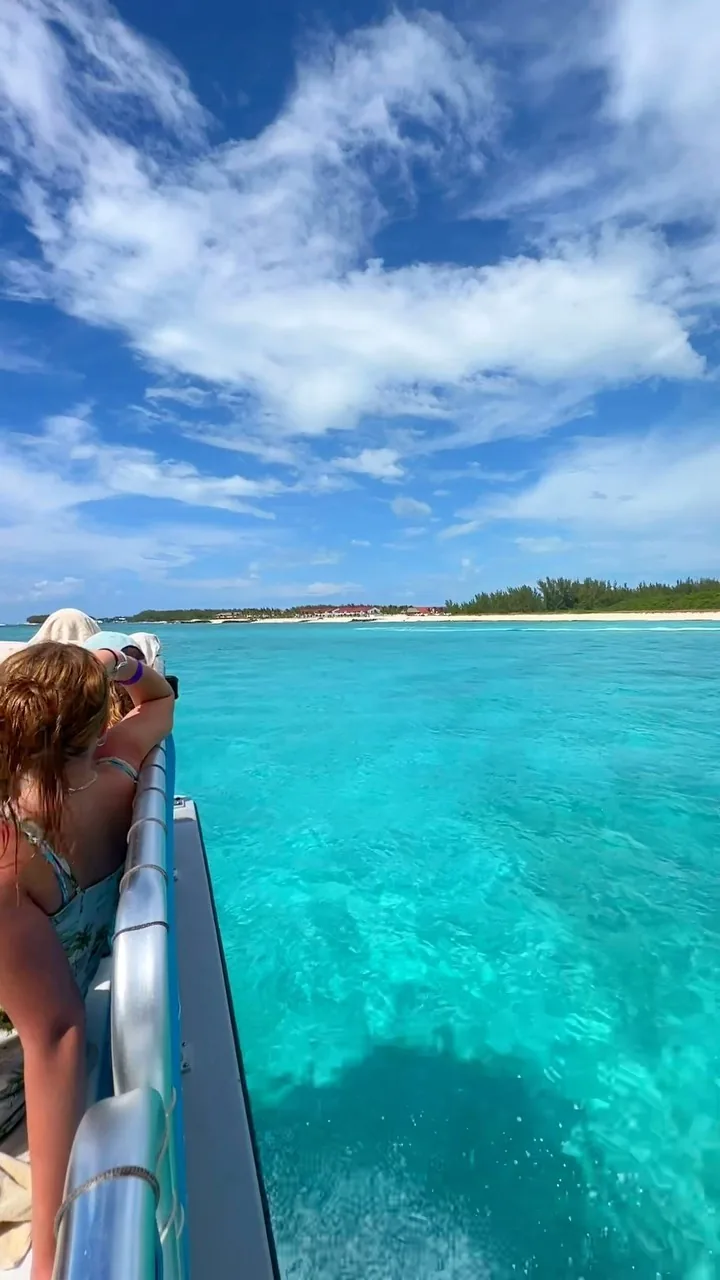 Looking out over the bow of a boat across bright turquoise Bimini water